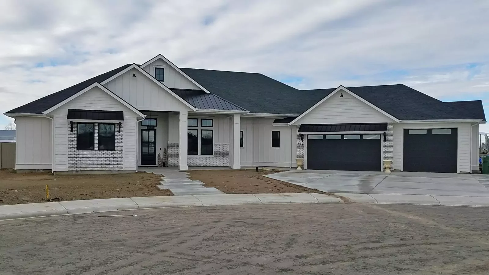New garage doors installed on a farmhouse-style home by Overhead Door Company